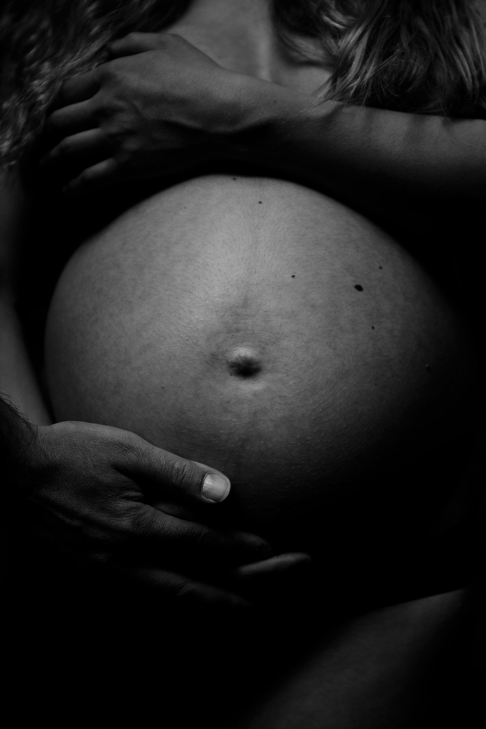Schwangerschaftsfotos Berlin _ Nackter Babybauch mit Hand des werdenden Vaters