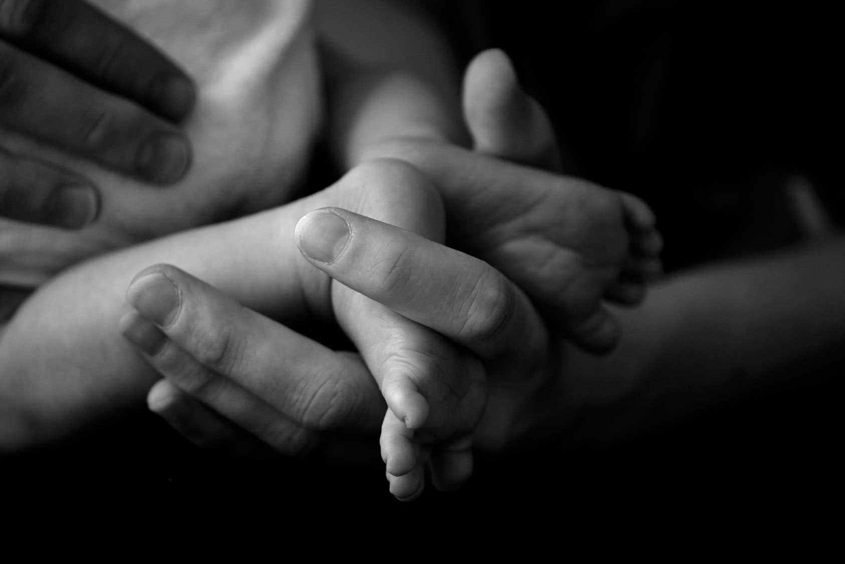 Neugeborenenfotos Berlin - Babyfüße in Hand von Mama Detail Neugeborenes
