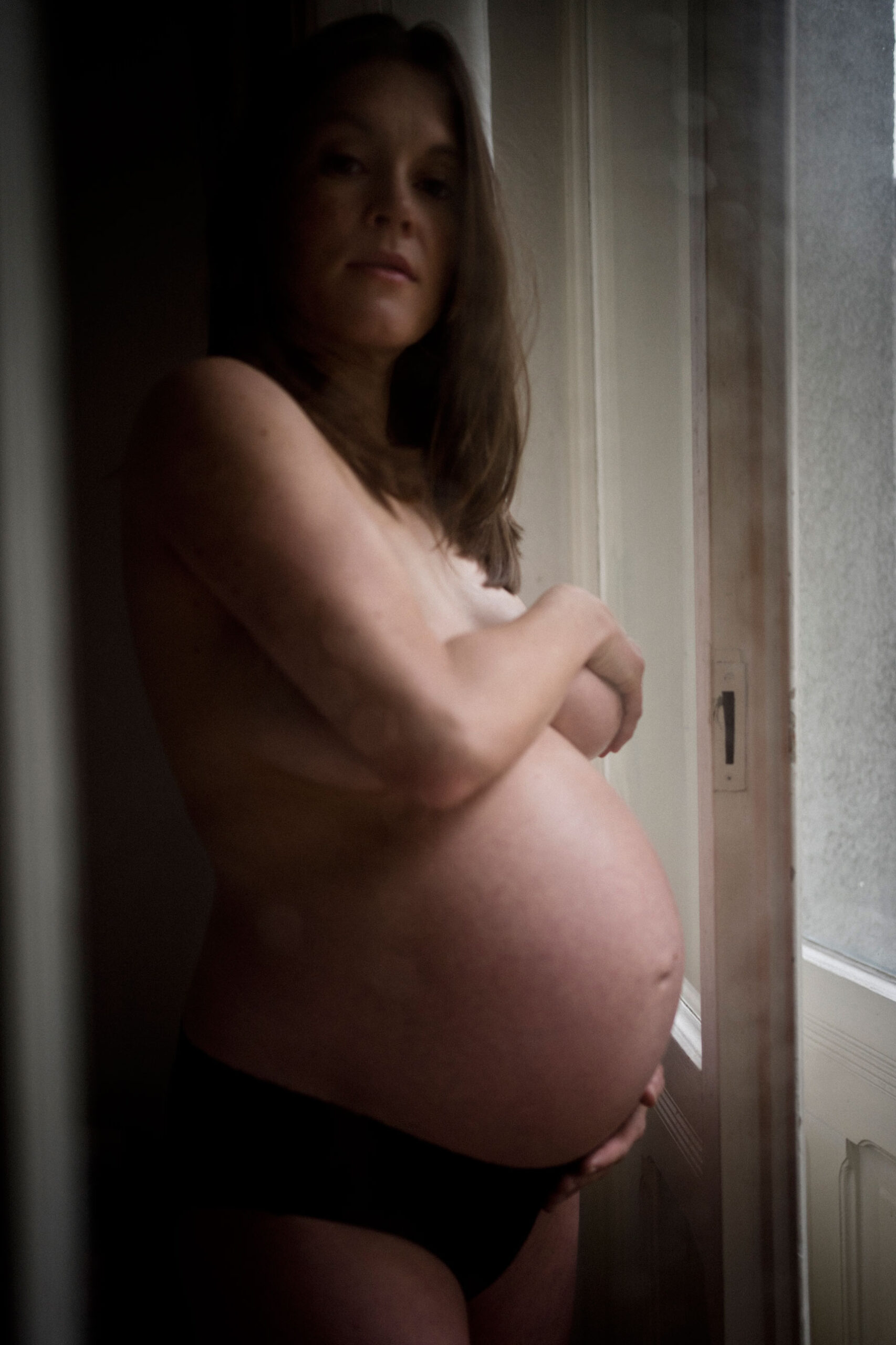 Schwangerschaftsfotos Berlin - Schwangere hinter Glasscheibe