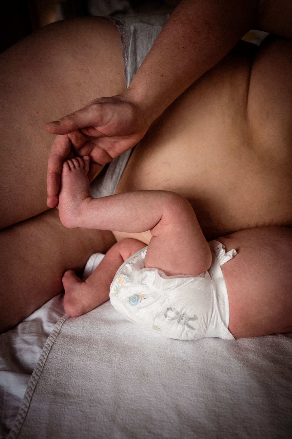 Neugeborenenfotos Berlin _ Detail beim Stillen Babyfuß in Mamas Hand