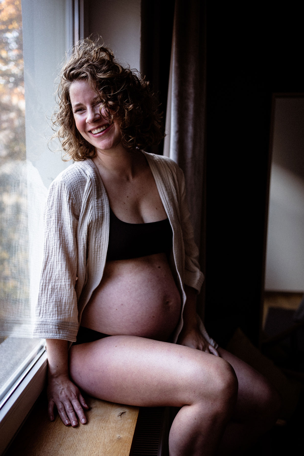 Schwangerschaftsfotos Berlin_Lachende Schwangere am Fenster