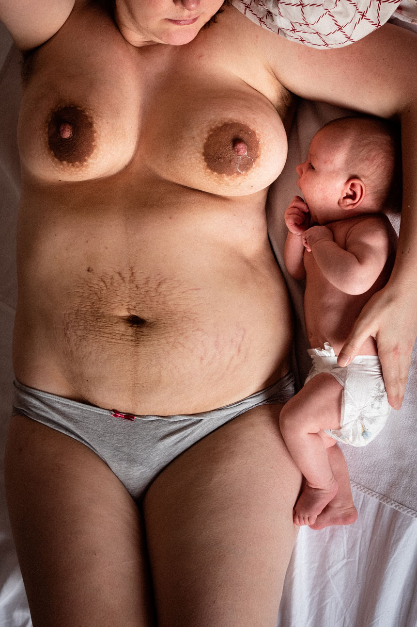 Neugeborenenfotos Berlin _ Nackte Mutter mit tropfender Brust mit Baby im Bett