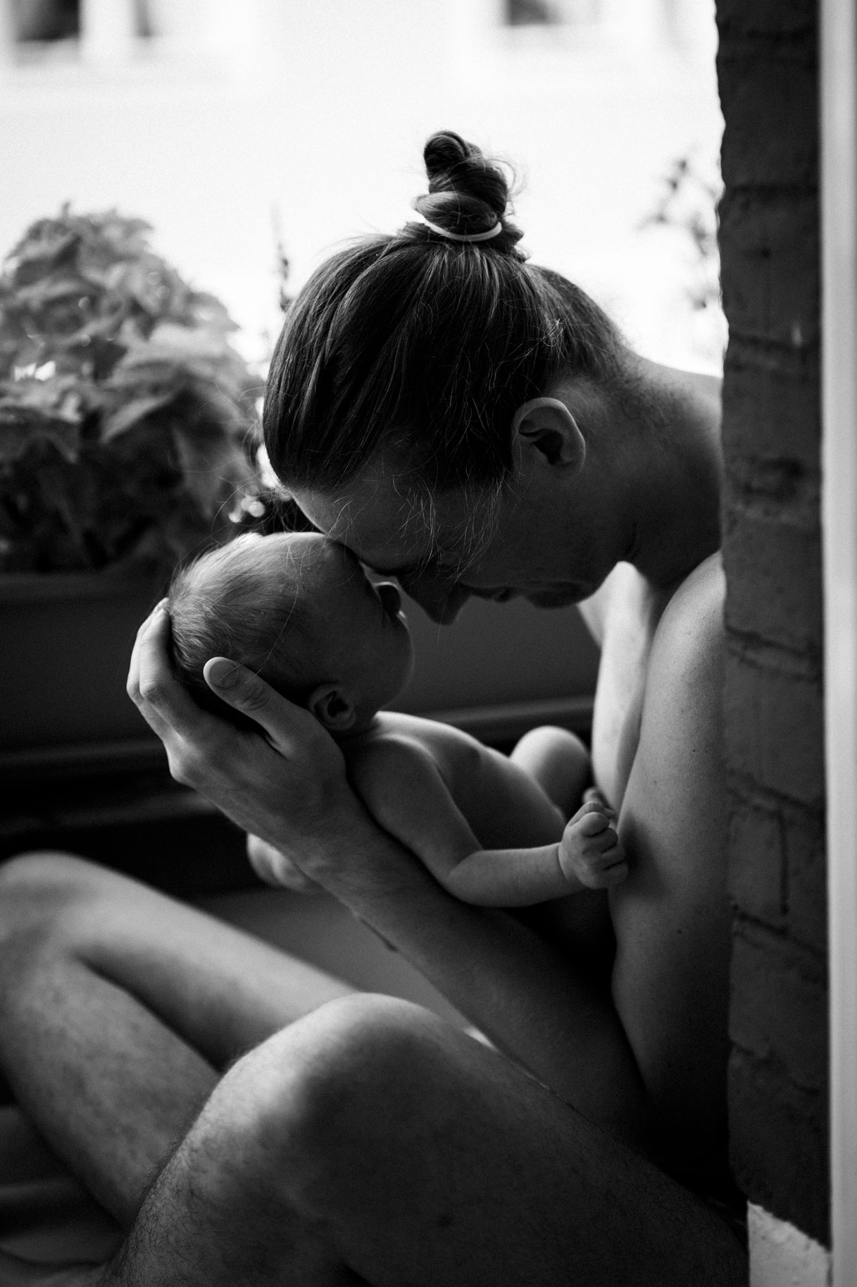 Neugeborenenfotos Berlin_Papa mit Baby im Arm auf Balkon