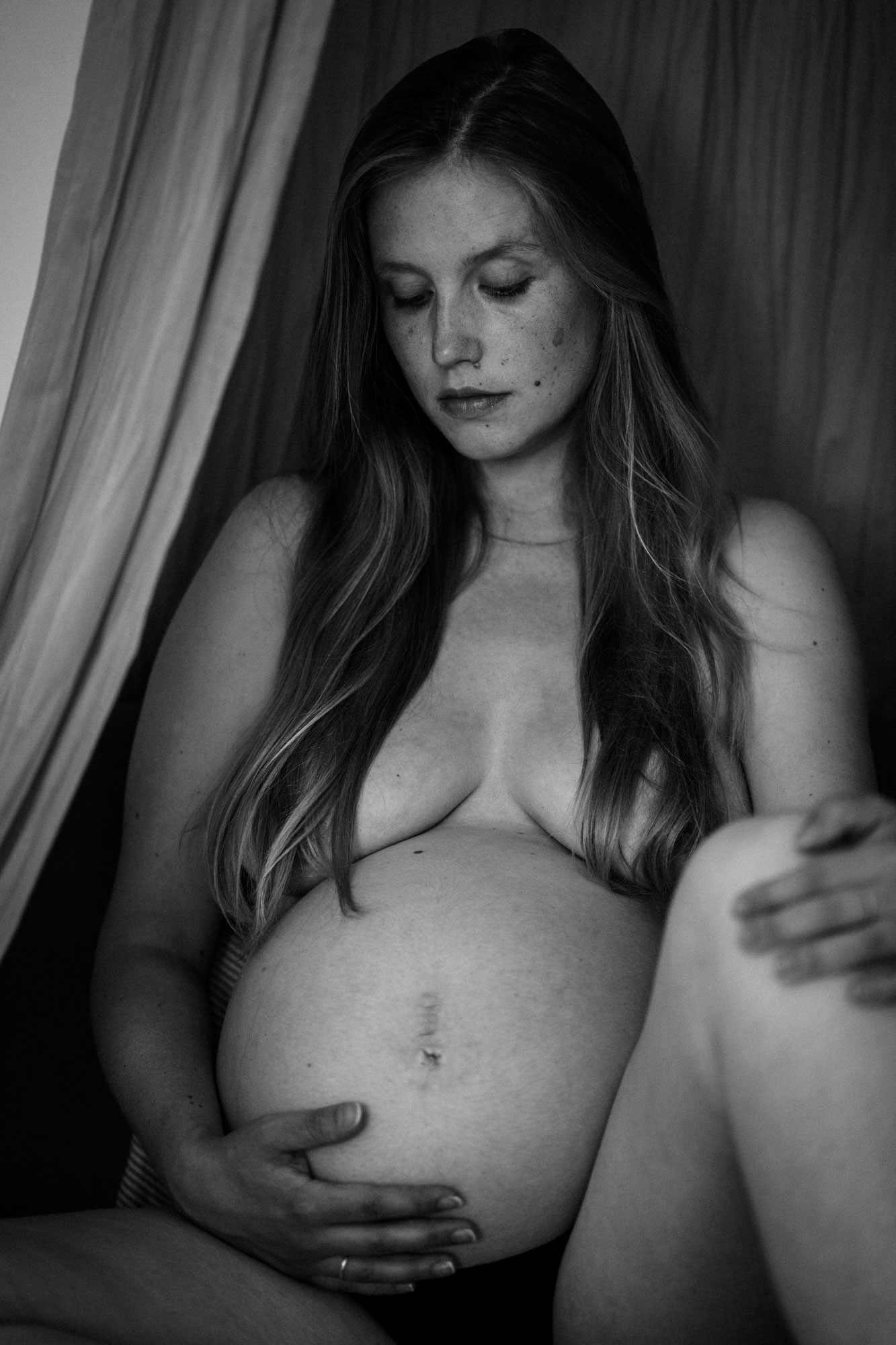 Schwangerschaftsfotos Berlin_Zuhause_Schwangere nackt auf Sofa_schwarz-weiß