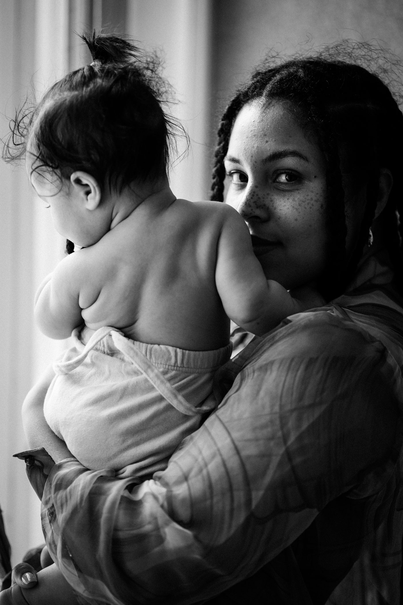 Familienfotos Berlin schwarz-weiß_Rola mit Baby an Fenster
